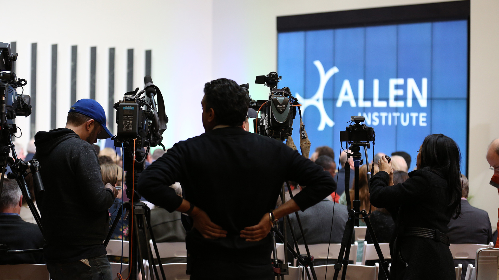 http://TV%20news%20cameras%20shooting%20an%20Allen%20Institute%20press%20conference%20in%20the%20building's%20atrium