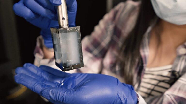 Scientist holding up research equipment